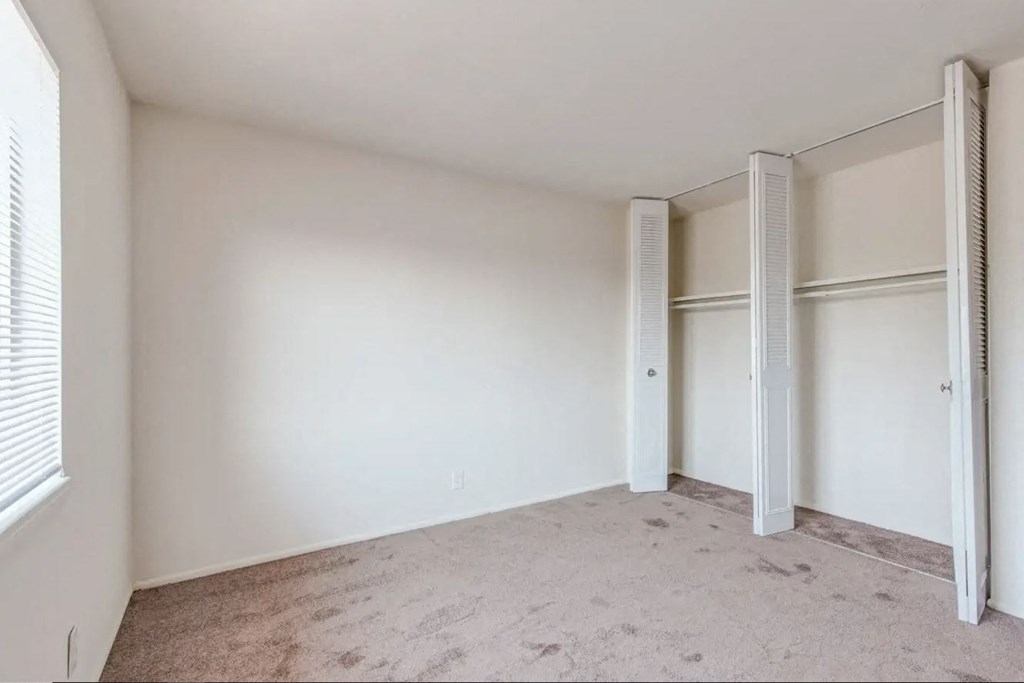 a bedroom with white walls and a carpeted floor