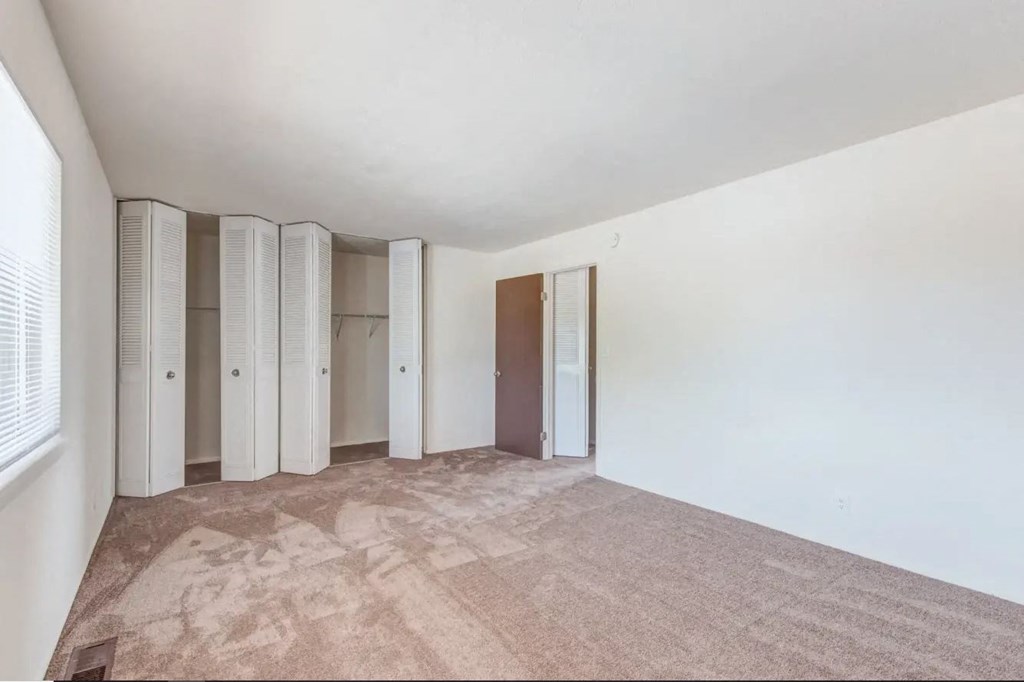a bedroom with white walls and a carpeted floor