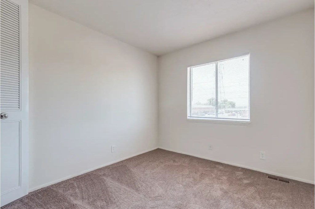 a bedroom with a window and a door