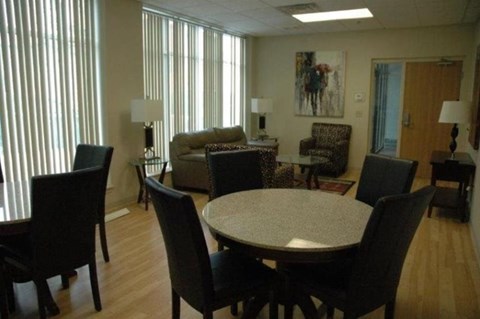 A living room with a table and chairs.