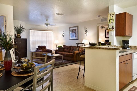 A kitchen and dining area with a table set for two.