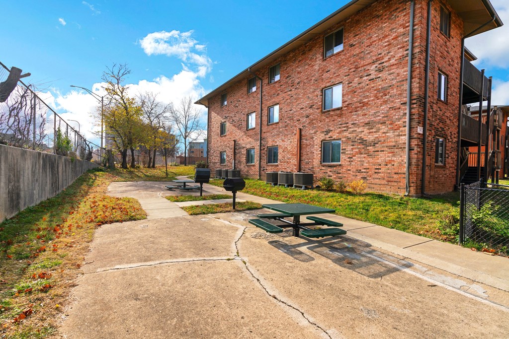 a picnic area in front of a brick building