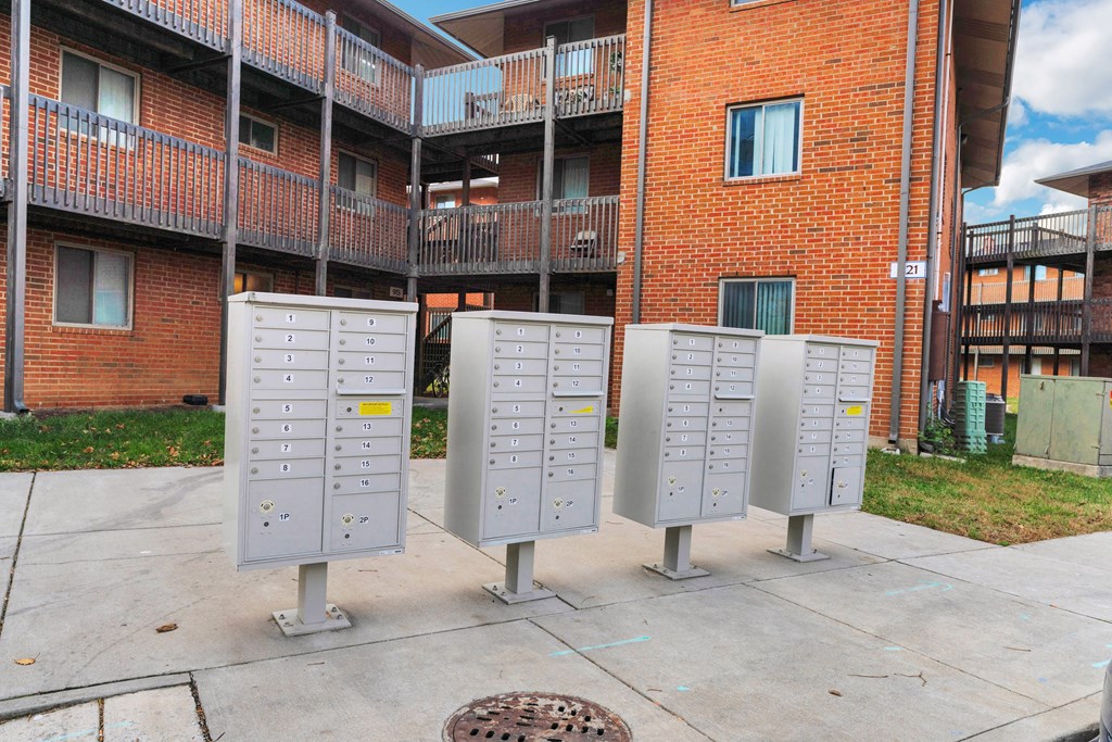 four metal mailboxes in front of a brick building