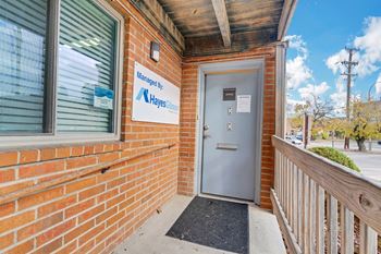 a brick building with a blue door and a sign that says affordable housing