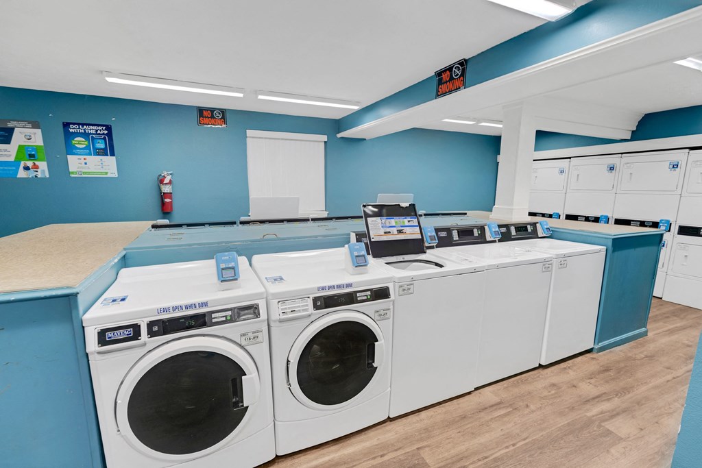 a washer and dryer area in a laundry room with four washing machines