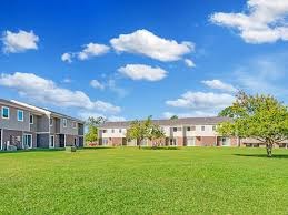 A row of houses with green lawns in front.