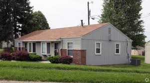 A house with a grey roof and a red brick chimney.