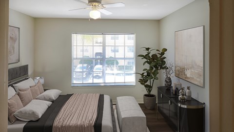 A bedroom with a large bed and a window with a view of a parking lot.