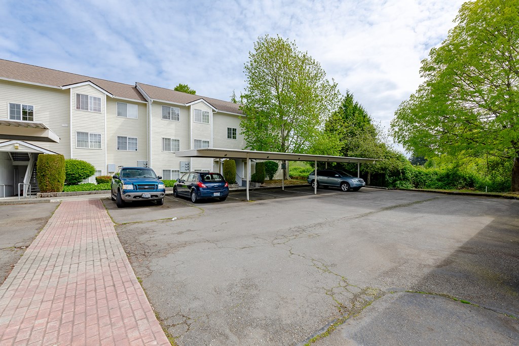 a parking lot with cars in front of a apartment building