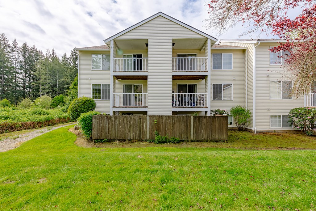 a white house with a yard and a wooden fence