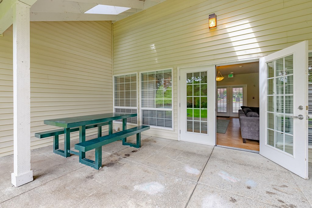a porch with a picnic table and a backdoor to a house