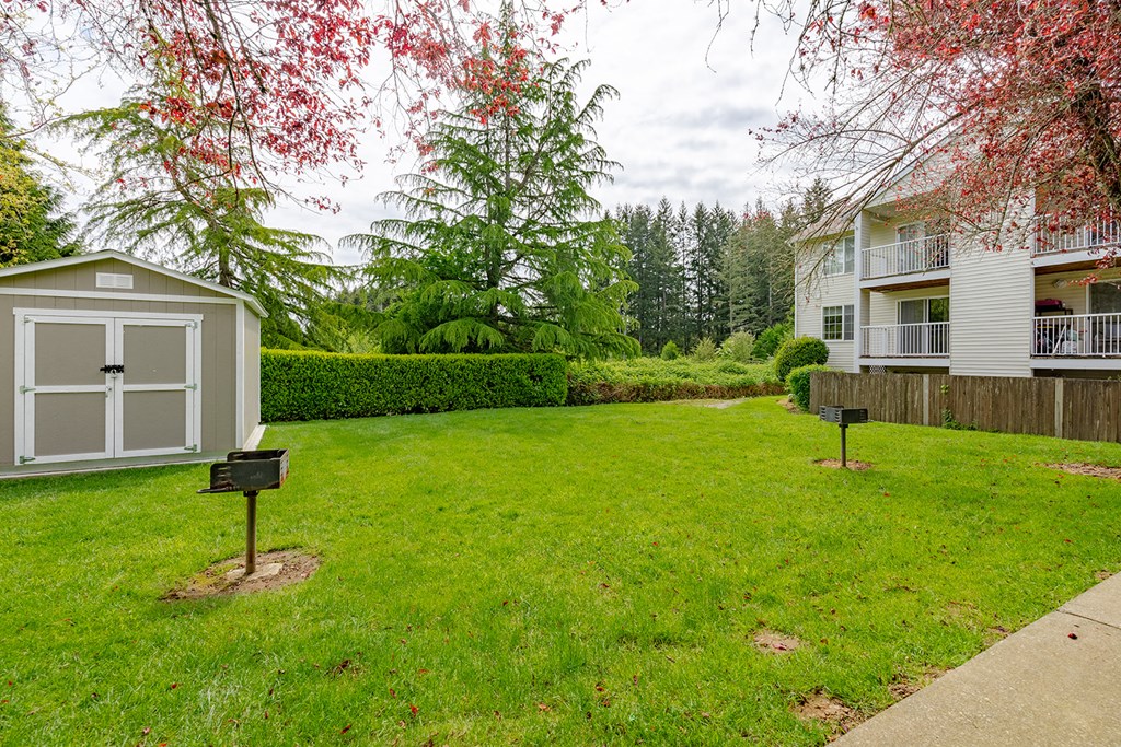 a yard with two small signs in the grass next to a building