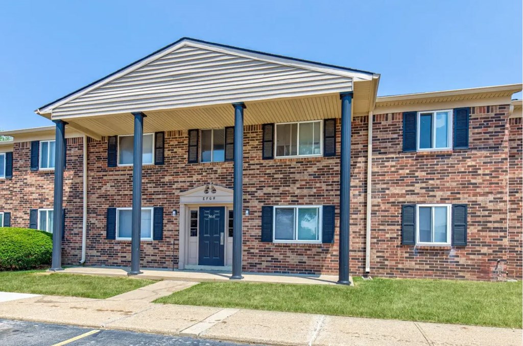 our apartments showcase a beautiful brick building with blue shutters and awning