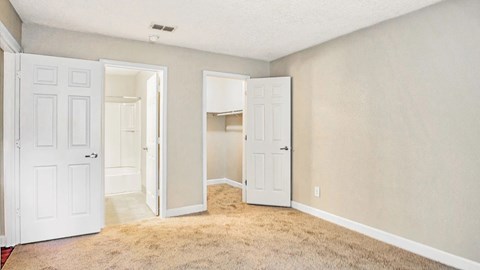 A room with two white doors and a carpeted floor.