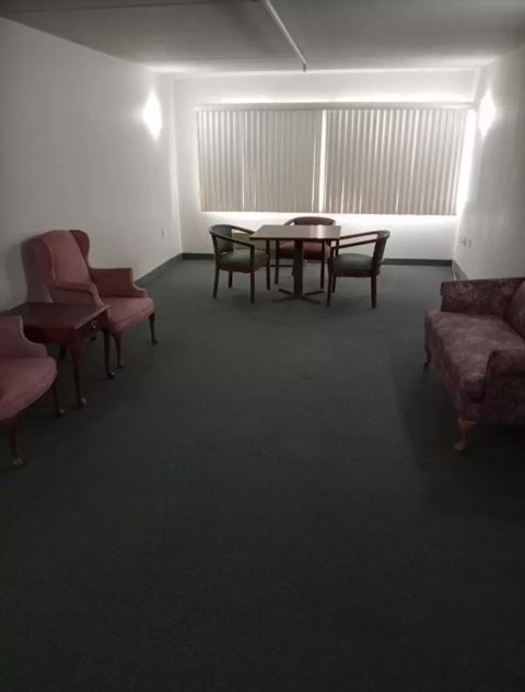 A room with a table, chairs and a couch.