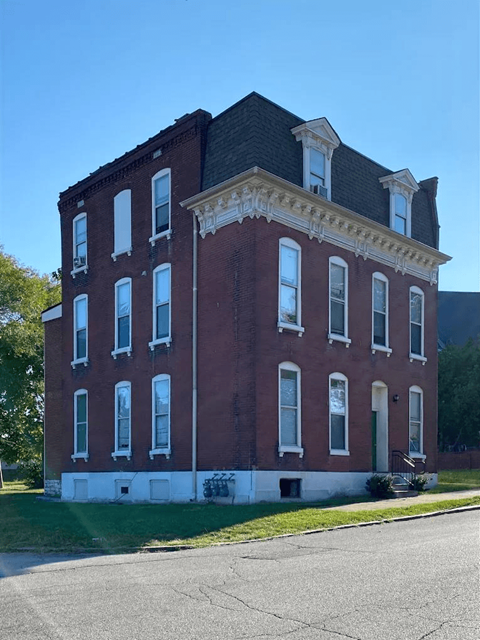 A red brick building with white trim and a black roof.