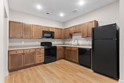 A kitchen with black appliances and wooden cabinets.