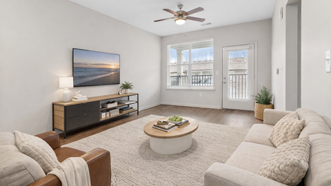 A living room with a brown couch, a coffee table, and a painting on the wall.