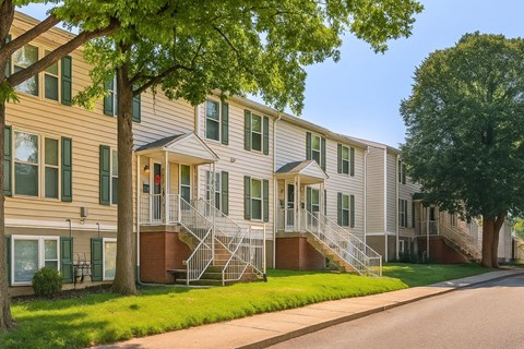 Apartment building with green trees in front.