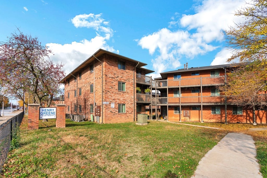 a brick apartment building with a sidewalk in front of it