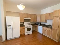 A kitchen with wooden cabinets and white appliances.