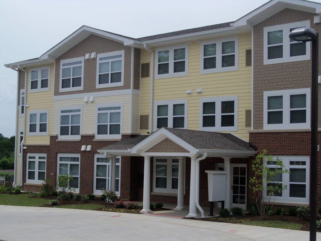 A two-story building with a front porch and multiple windows.