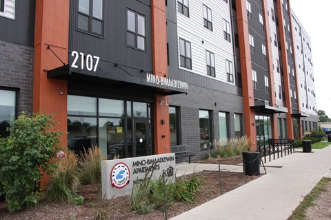 a building with a sidewalk and a sign in front of it