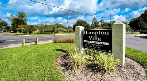 Hampton Villa Apartments sign in front of a grassy area.