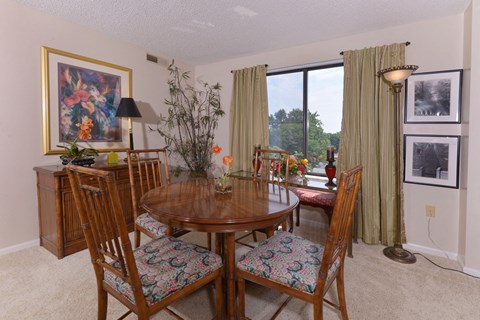 A dining room with a wooden table and chairs.