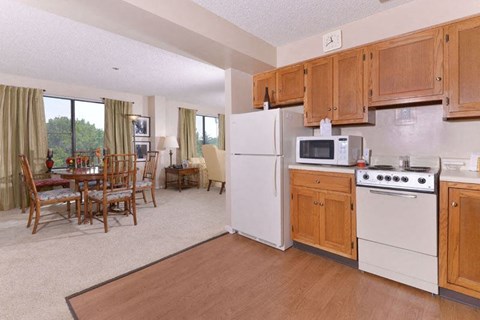 A kitchen with white appliances and wooden cabinets.