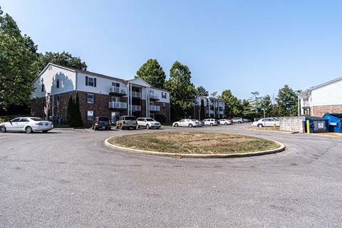 A parking lot with cars and apartment buildings in the background.