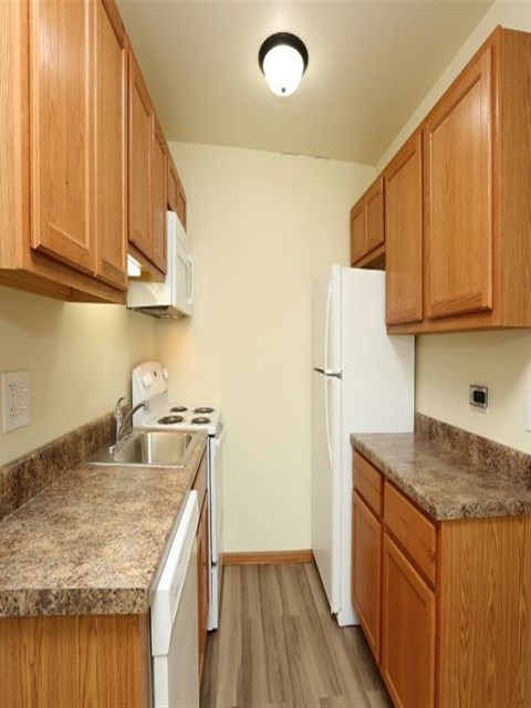 A kitchen with wooden cabinets and a granite countertop.