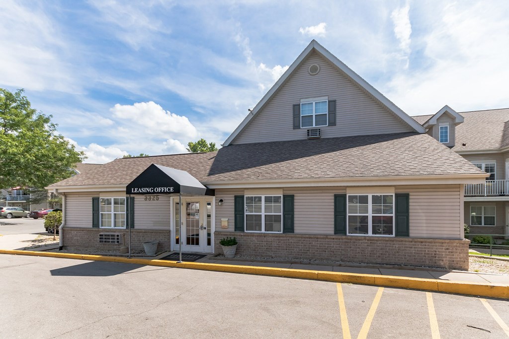 A Leasing Office building with a parking lot in front.