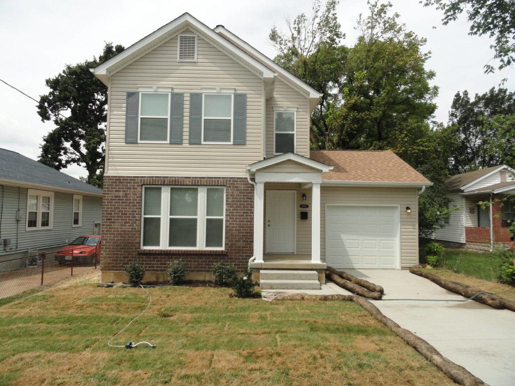 A house with a grey roof and a white garage door.