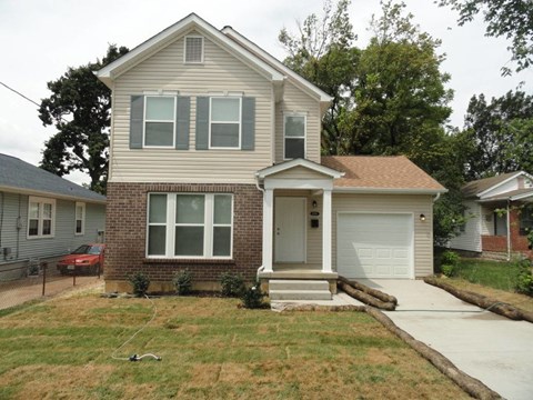 A house with a grey roof and a white garage door.
