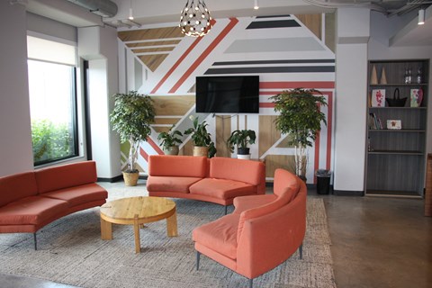 A living room with a striped wall and a television.