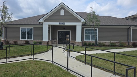 A grey building with a black railing in front.