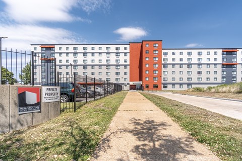A private property sign is on a wall in front of a building.