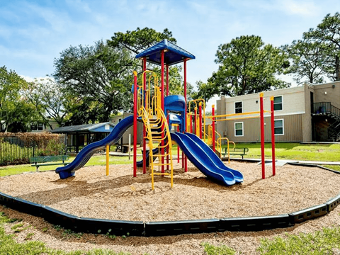 A playground with a blue and yellow slide.