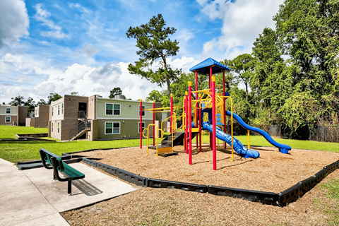 A playground with a blue slide and a red and yellow structure.