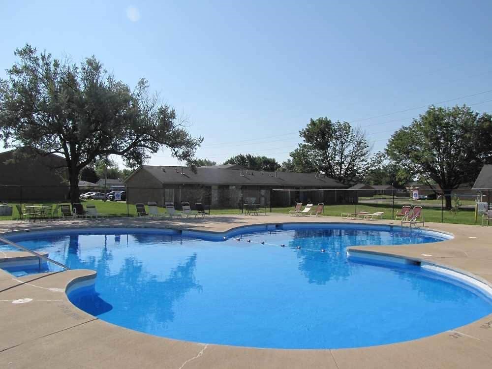 a swimming pool with trees in the background