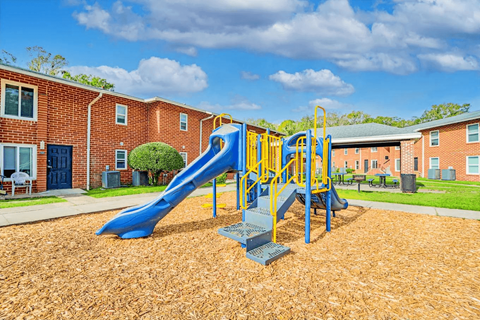 A playground with a blue slide and yellow railing.