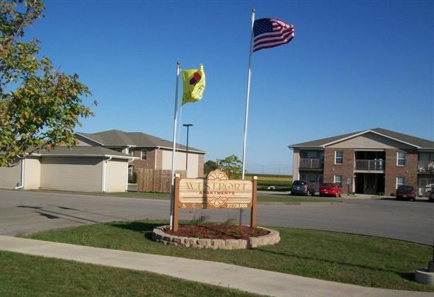 A sign that says "Welcome" is in front of a building.
