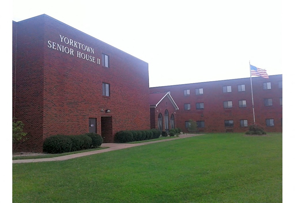 a large brick building with an flag in front of it