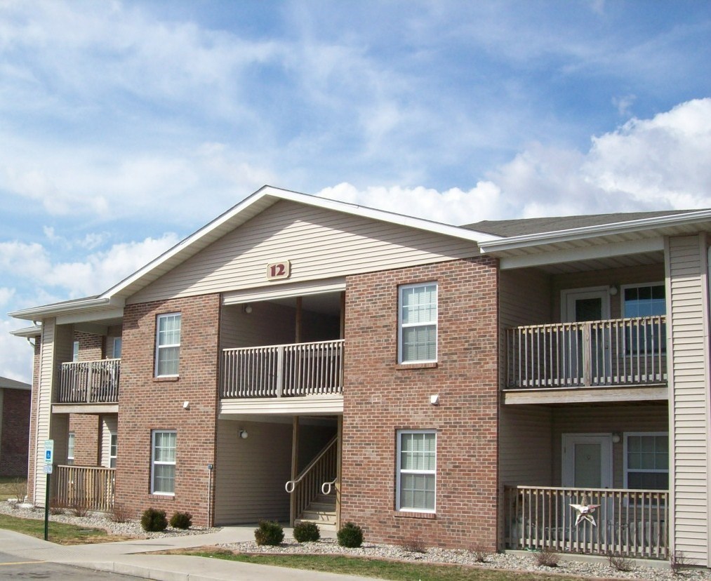 Apartment building with a balcony on the second floor.