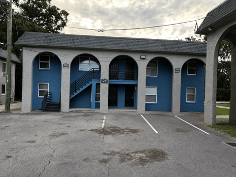 A blue building with arched windows and a staircase.