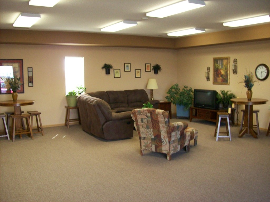 A living room with a couch, chair, and television.