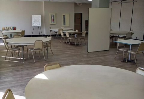 A white table is in the middle of a room with chairs around it.