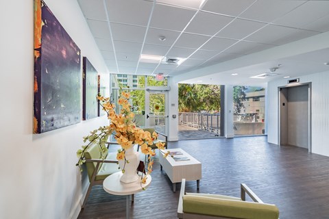 A brightly lit office space with a vase of flowers on a table.