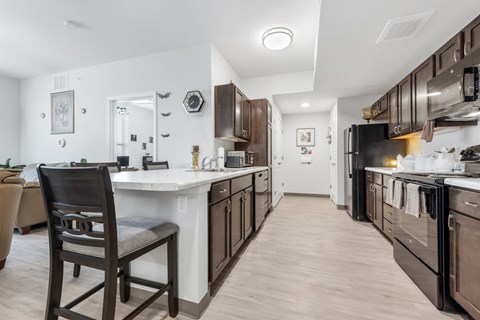 A kitchen with a white countertop and dark brown cabinets.